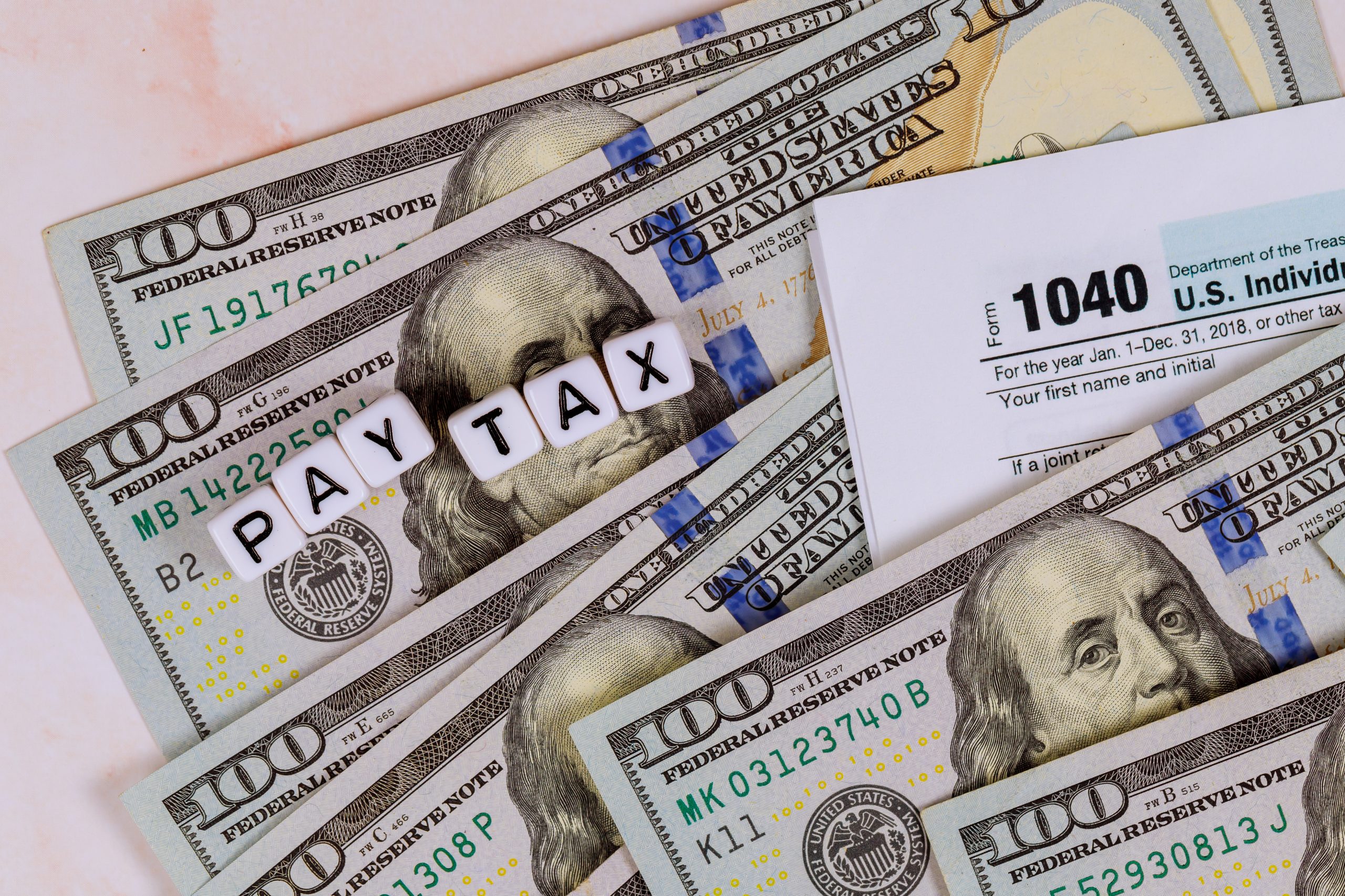 U.S. Individual Income Tax Return form 1040 and hundred dollar bills Pay Tax
